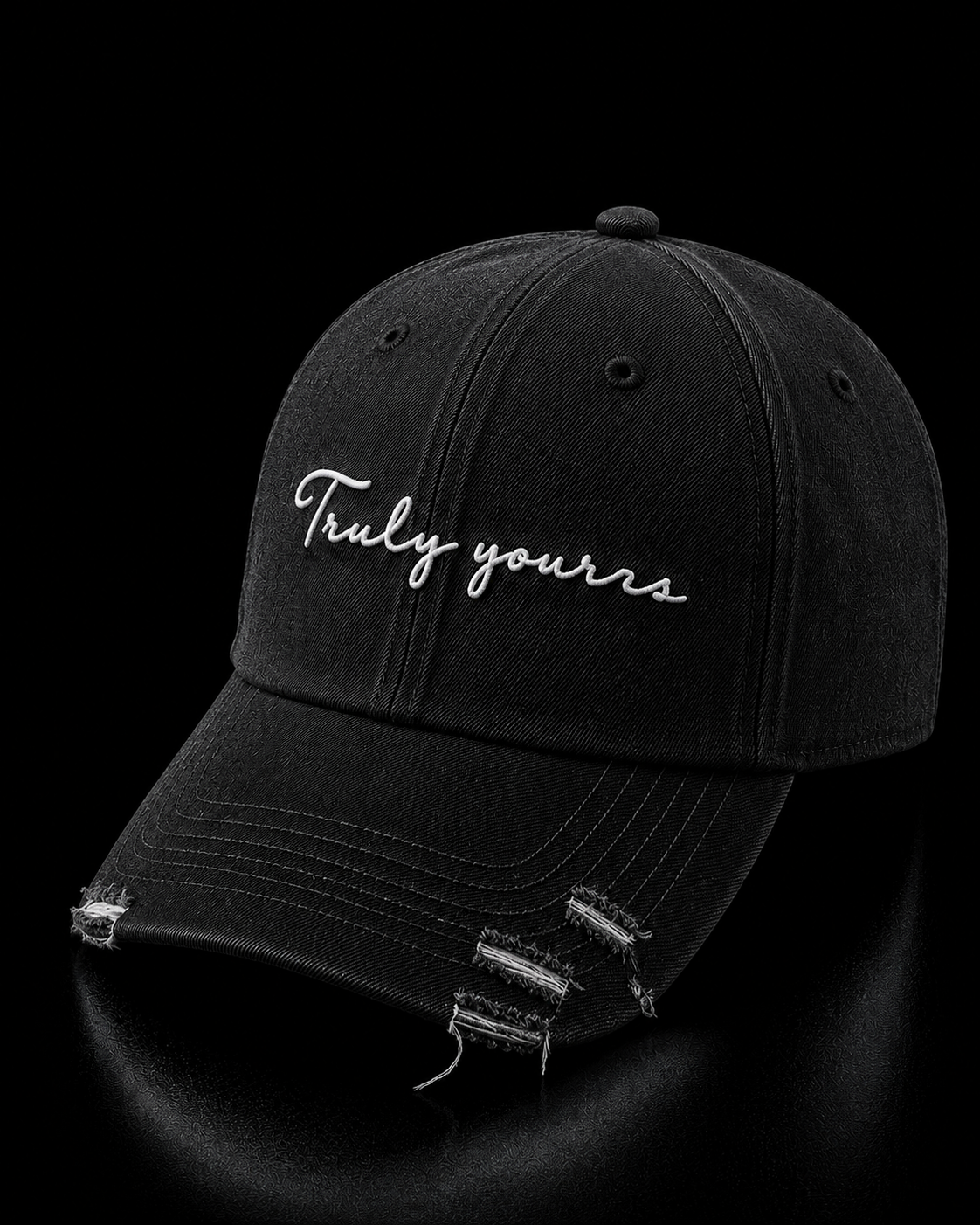 Black distressed baseball cap with 'Truly yours' text on a black background