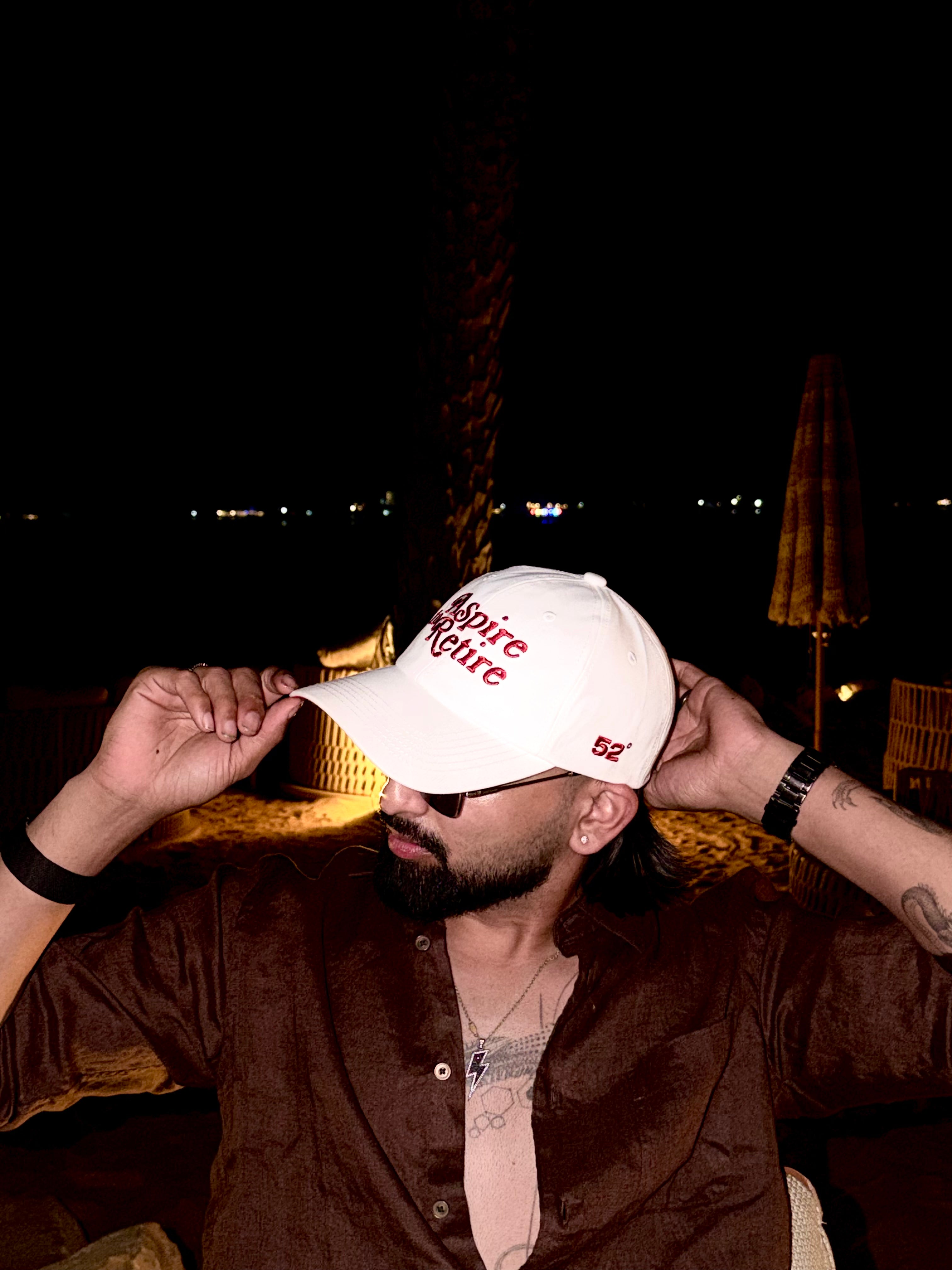 Man wearing a white cap with red text at night