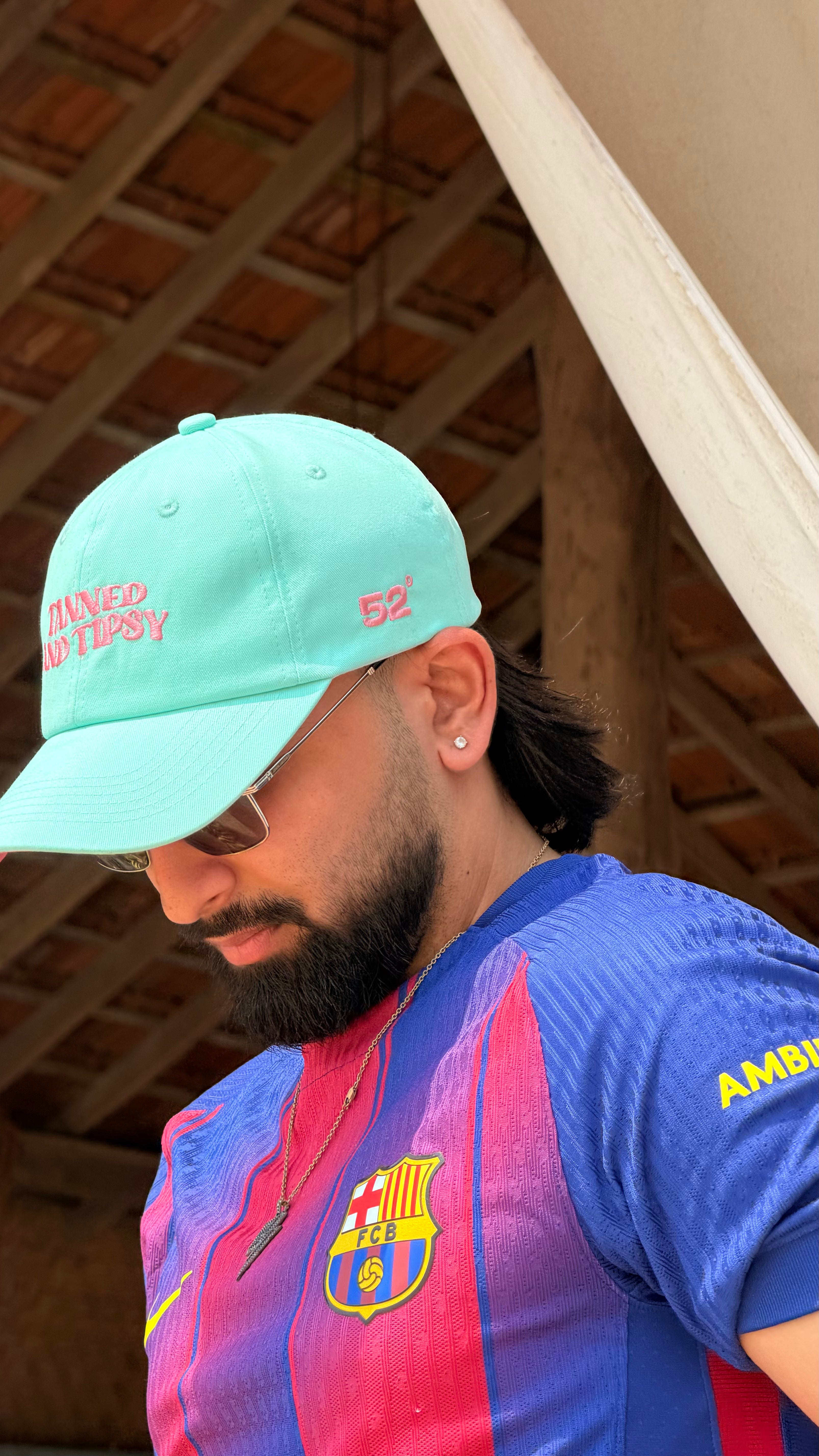 Man wearing a colorful sports jersey with a cap indoors