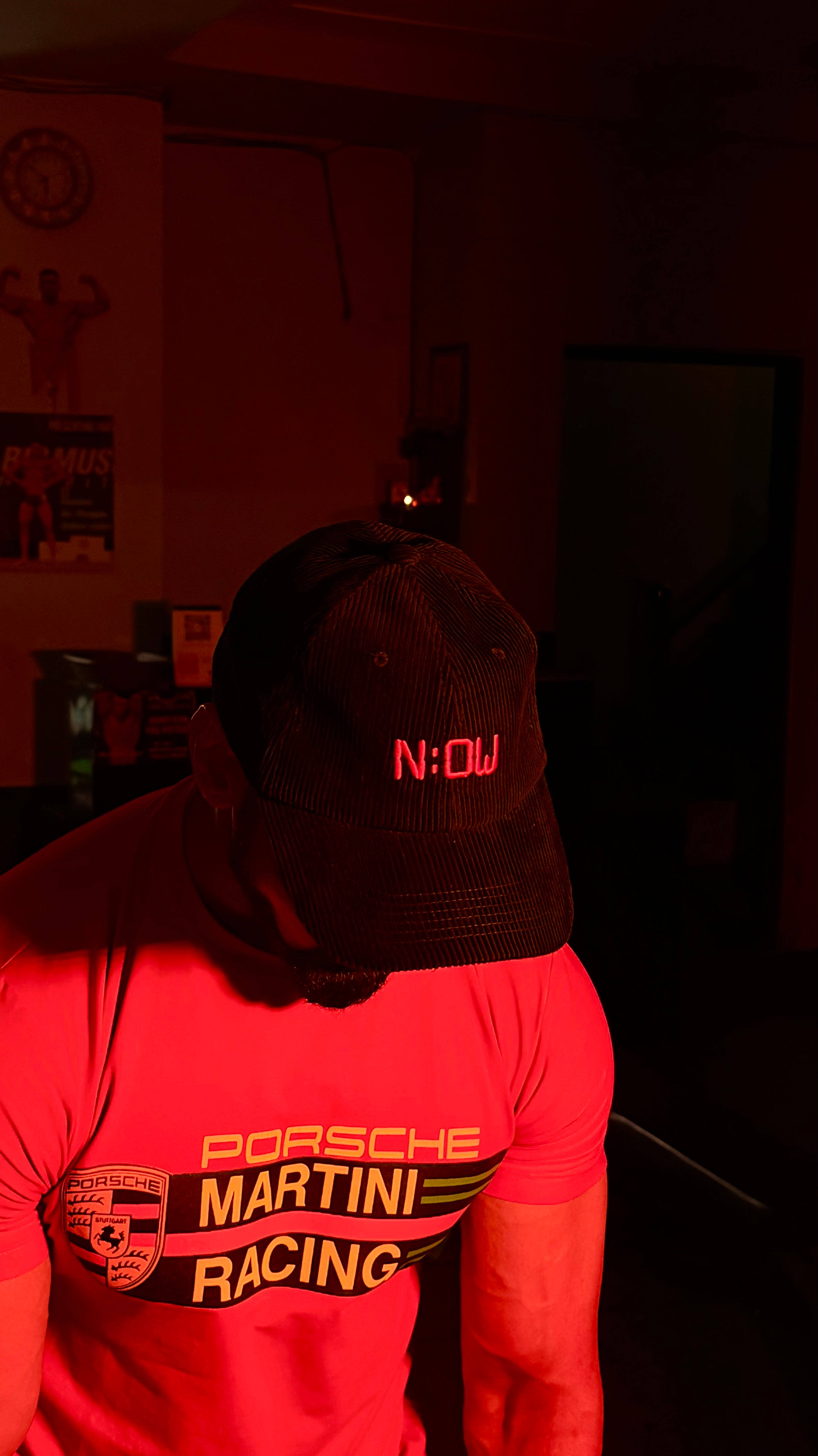 Person wearing a black cap with 'NOW' in red text.