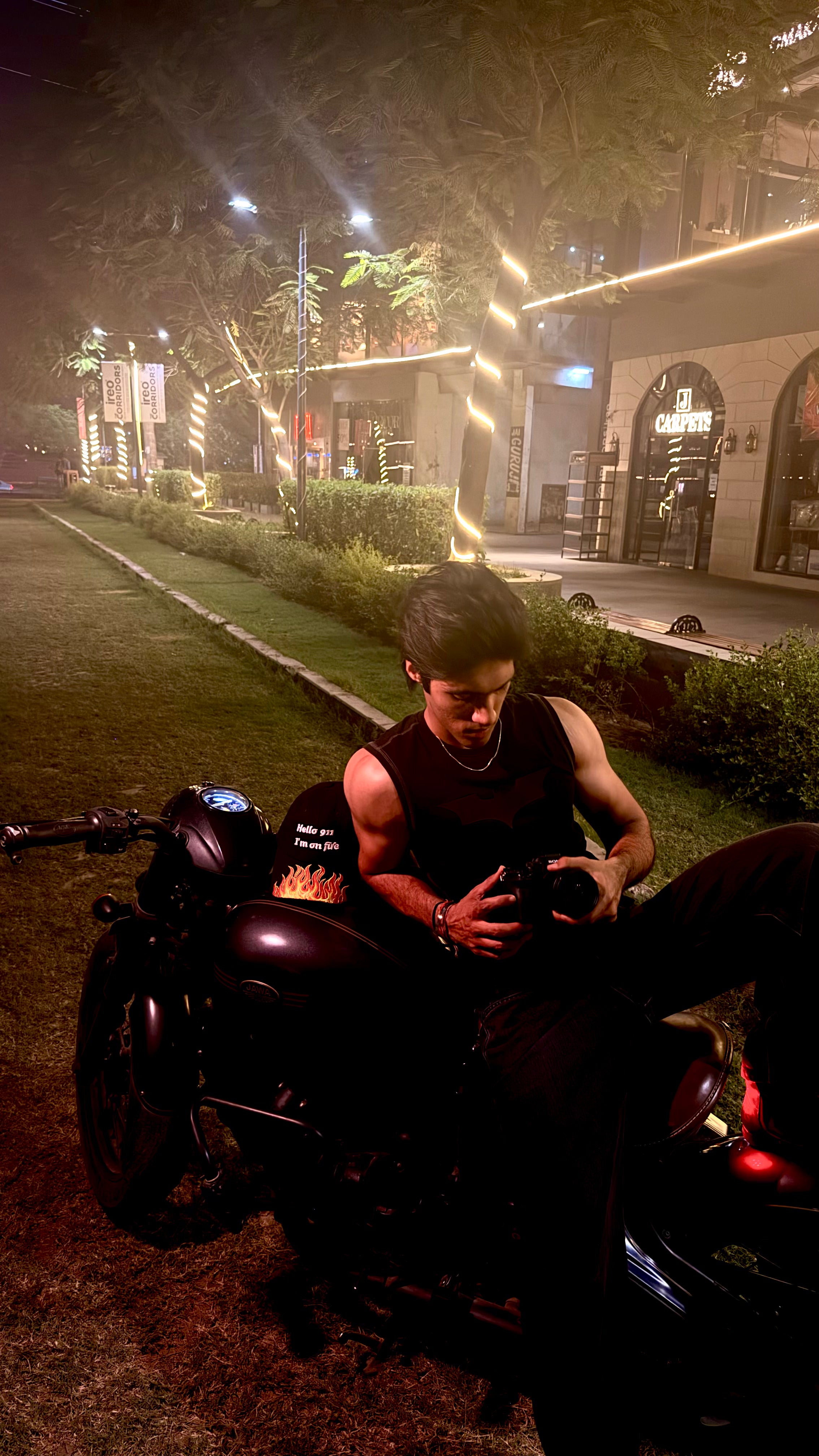 Man sitting on a motorcycle at night in an urban setting