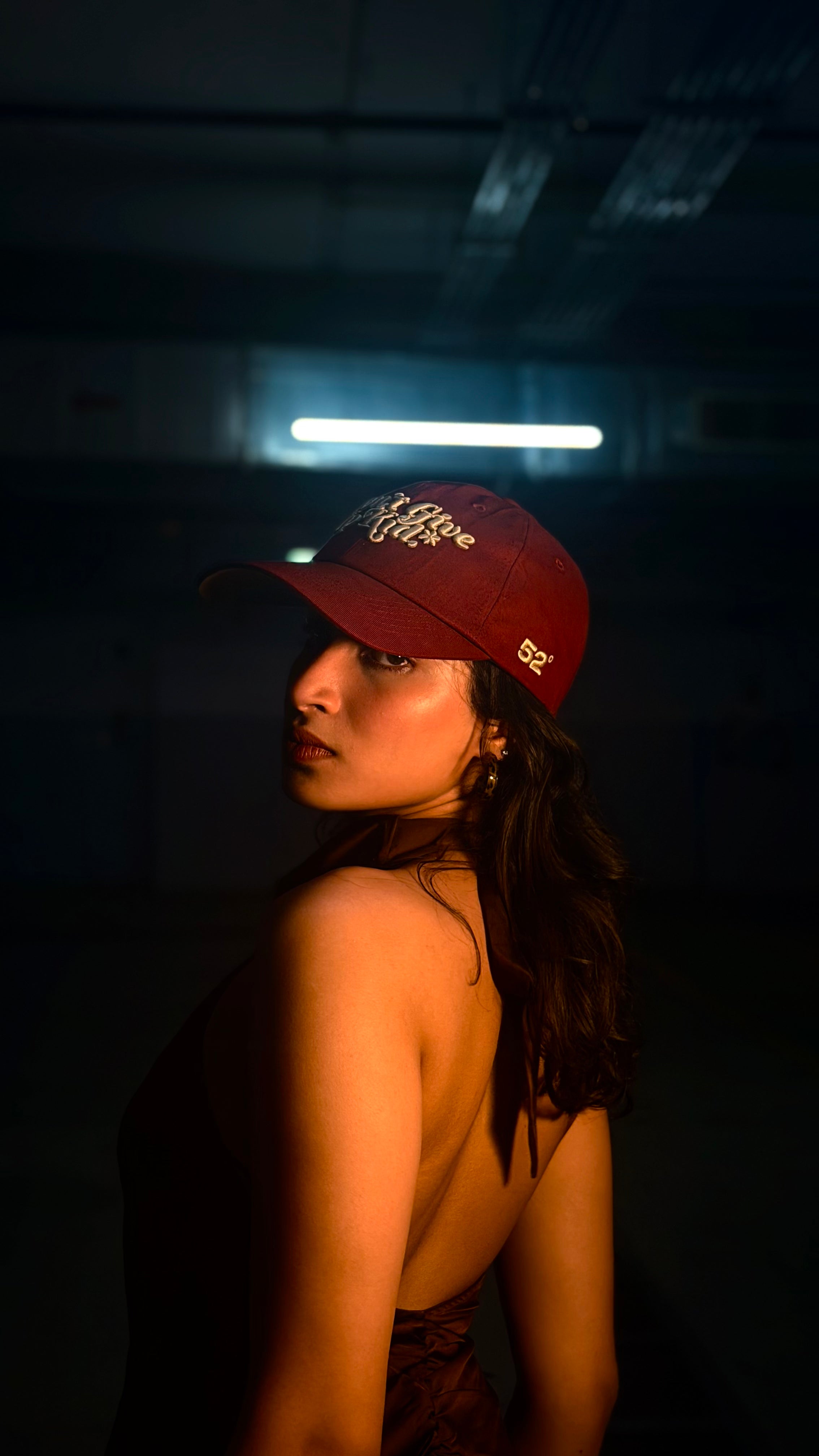 Person wearing a red cap in a dark setting