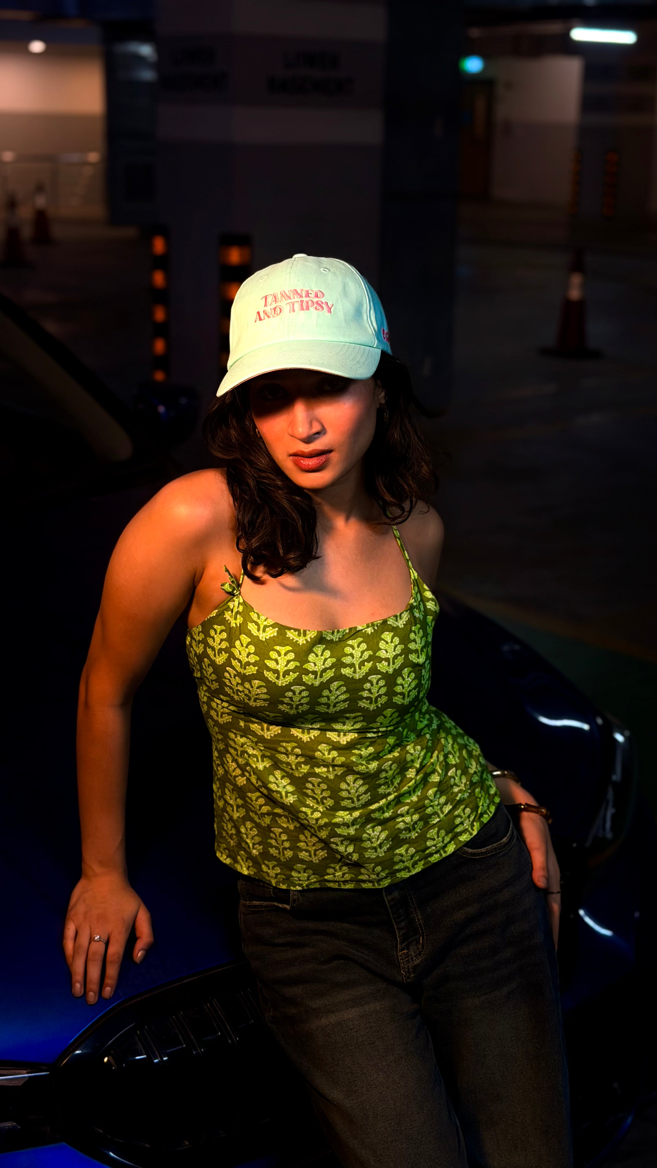 Woman wearing a green top and MINT cap in a dark indoor setting