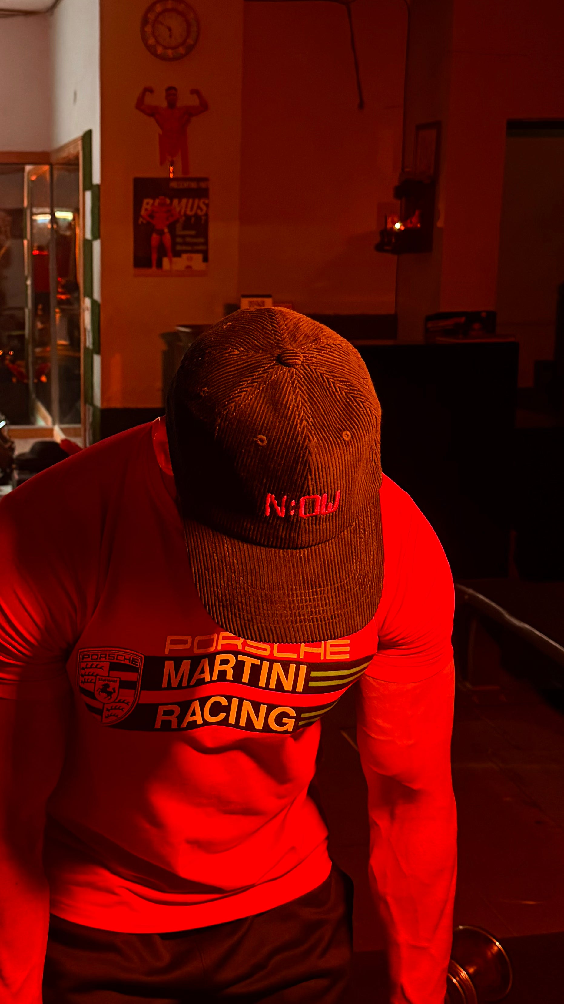 Person wearing black cap in a dimly lit room.