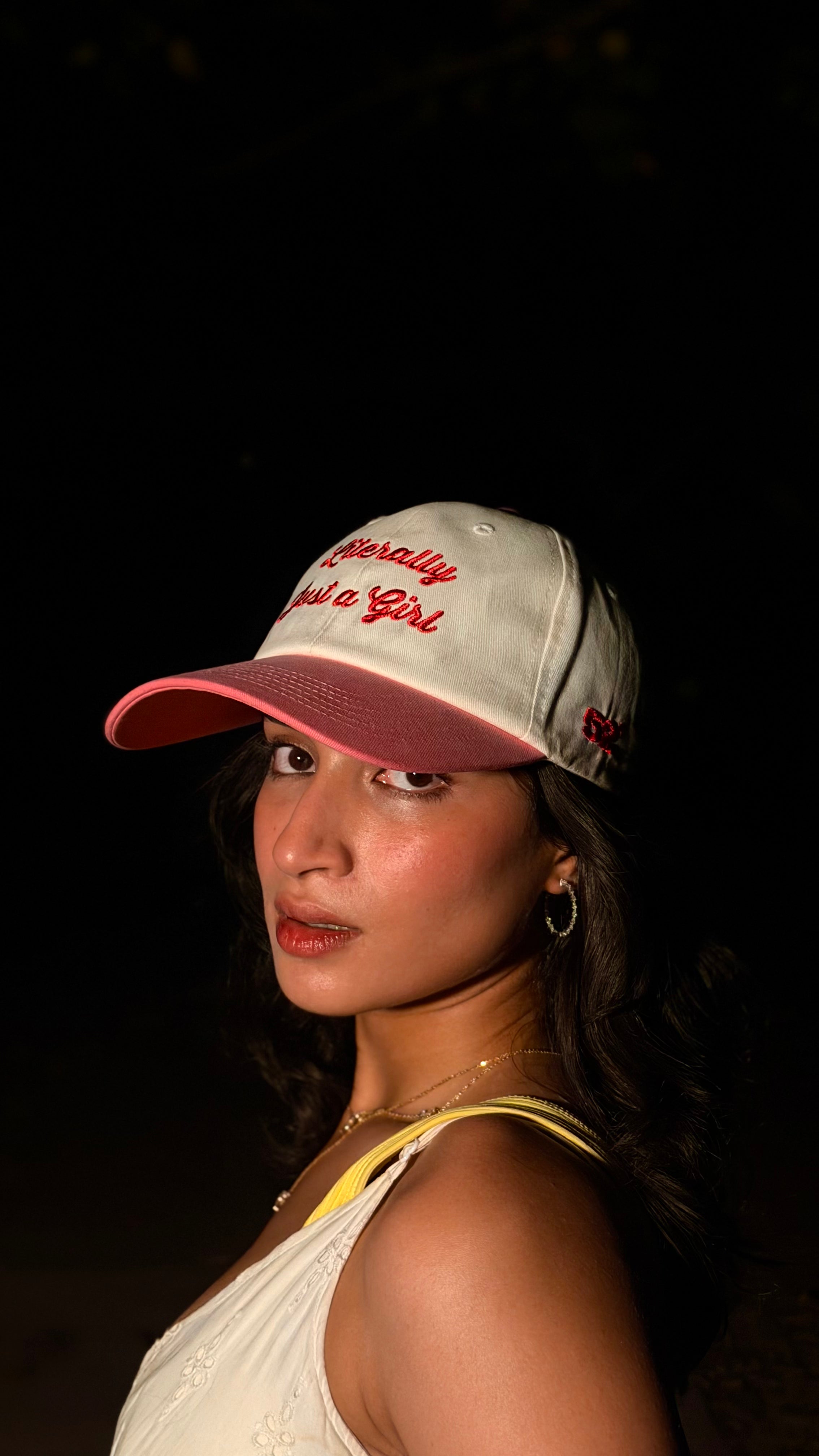 Woman wearing a cap with text against a dark background