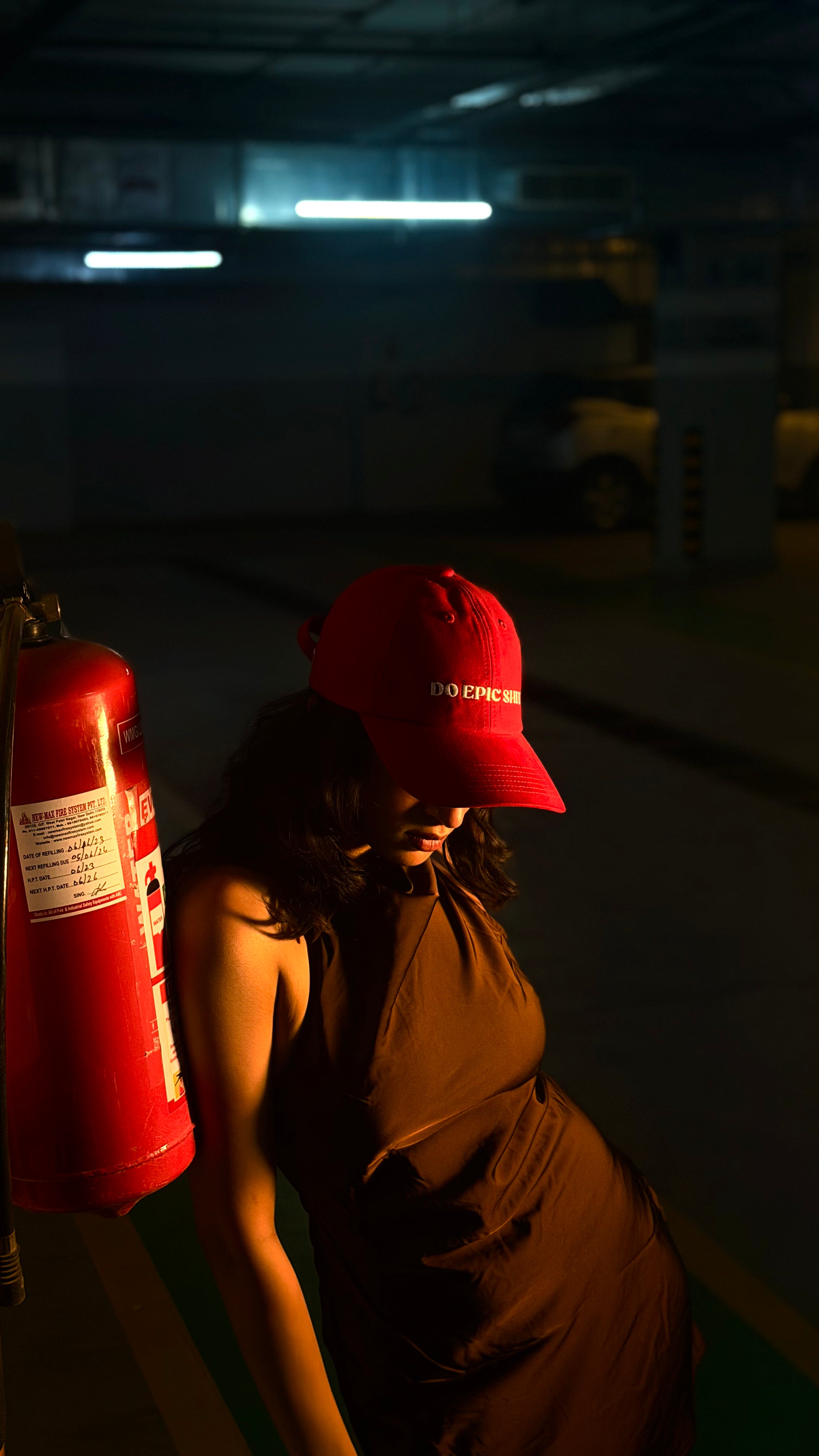 Person wearing a red cap with 'DO EPIC SHIT' logo in a dimly lit room.